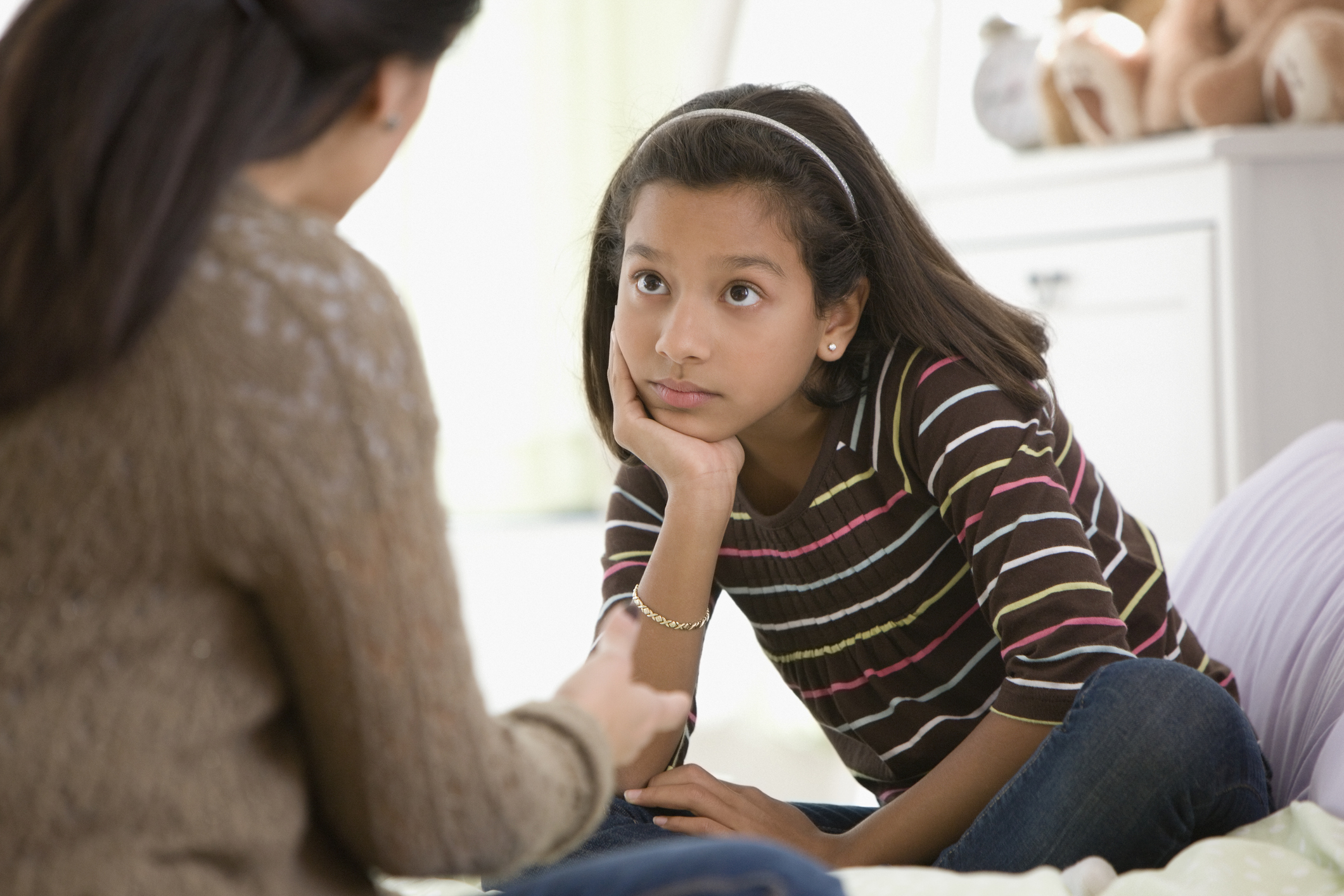 Mother talking to daughter in bedroom